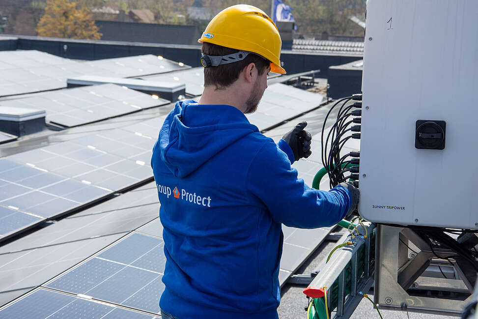 Installateur die zonnepanelen plaatst op dak bedrijf