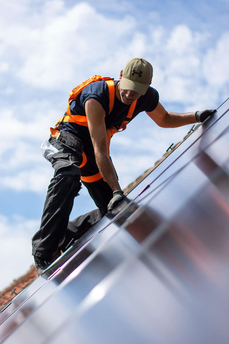 Installateur op dak die zonnepanelen installeert